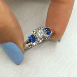 2.5Ct Round Cut Diamond Trilogy Ring 14K White Gold Finish Blue Sapphire Accents